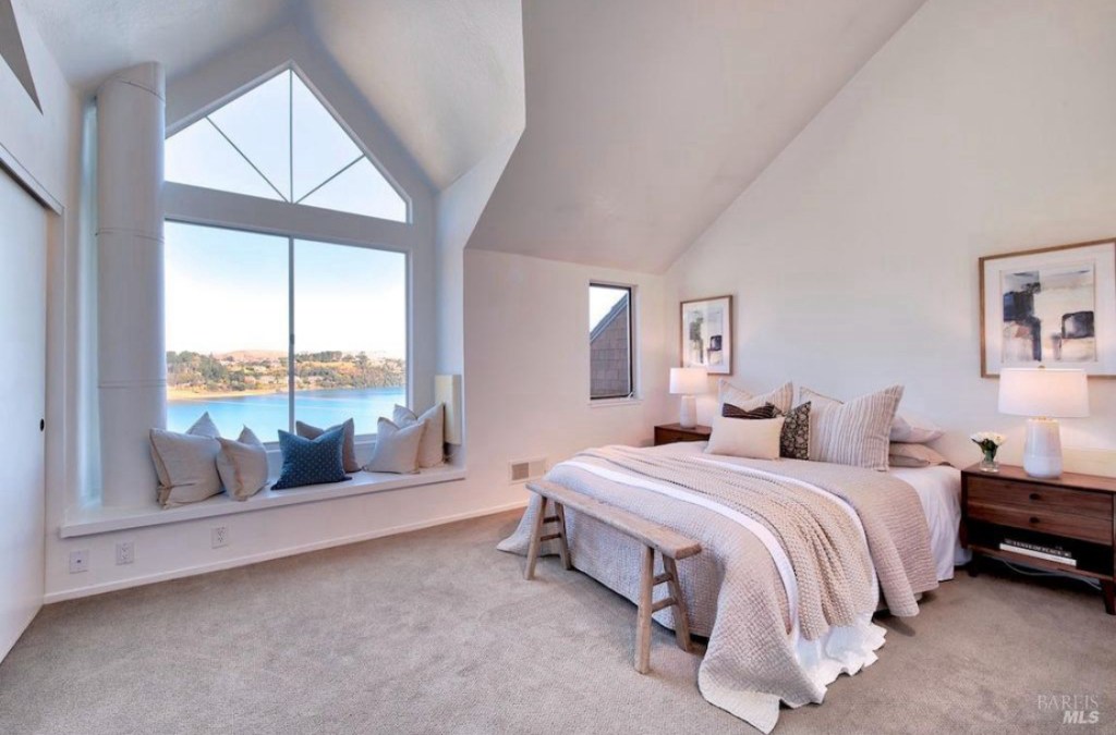 Master bedroom staged in a Sausalito, Marin County home with modern furniture, cozy bedding, and natural light highlighting the room's spacious design and calming atmosphere.